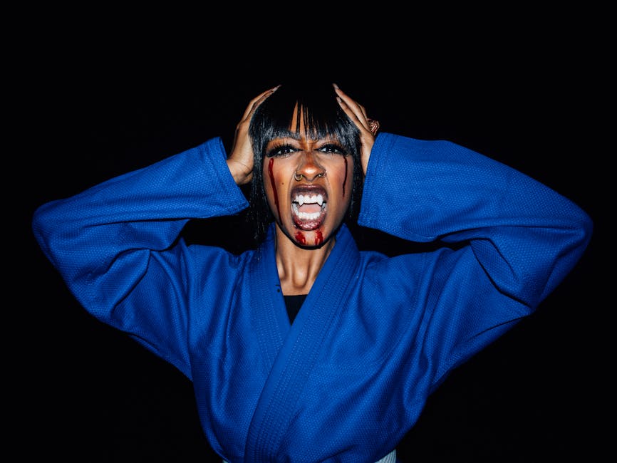 Creative Halloween portrait of a woman in a karate uniform with vampire makeup.