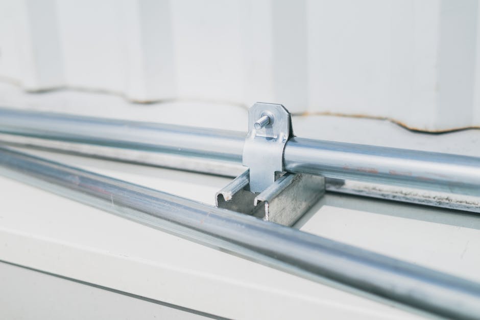 Detailed close-up of a metal pipe clamp on a stainless steel surface, highlighting industrial design.