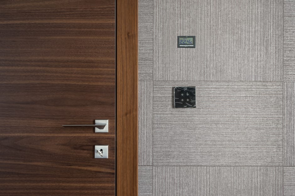Sleek modern wooden door with stainless steel handle and 22.4°C display.