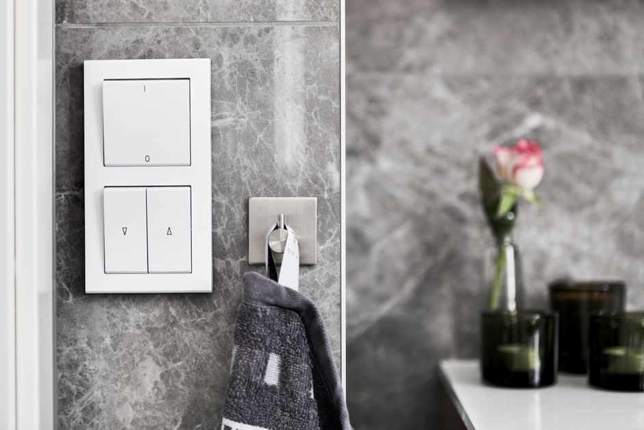 Elegant bathroom featuring marble wall, switch, and minimalist decor.