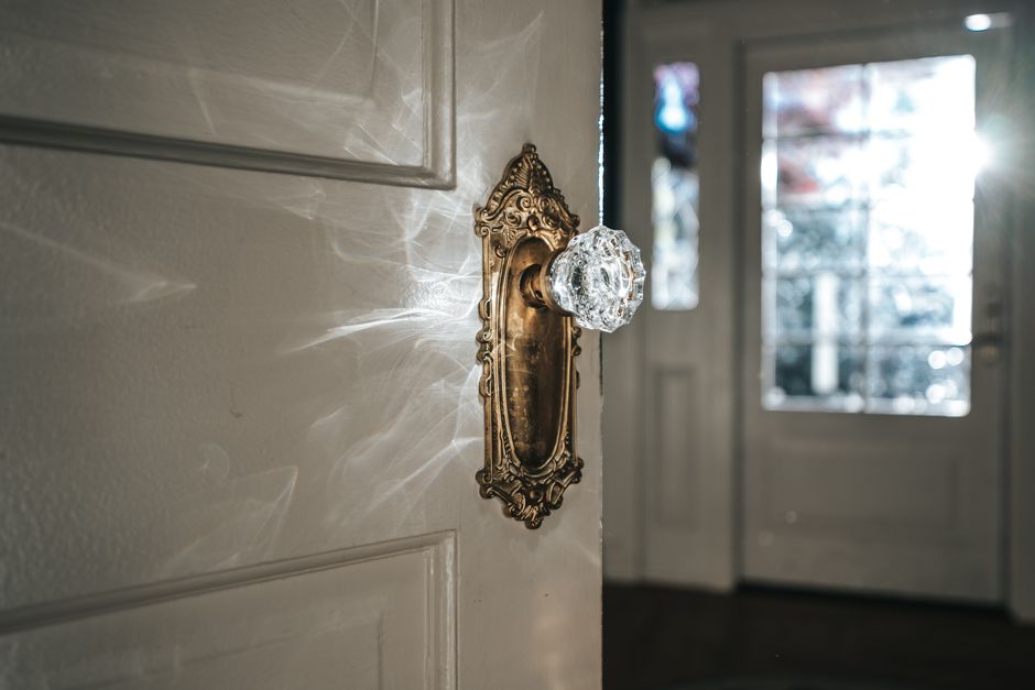 Elegant crystal doorknob with sunlight reflections, enhancing a vintage home interior atmosphere.