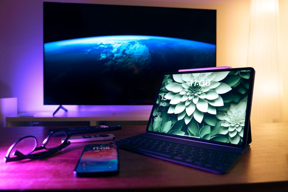 Stylish home office setup featuring devices like tablet, smartphone, and large screen display.