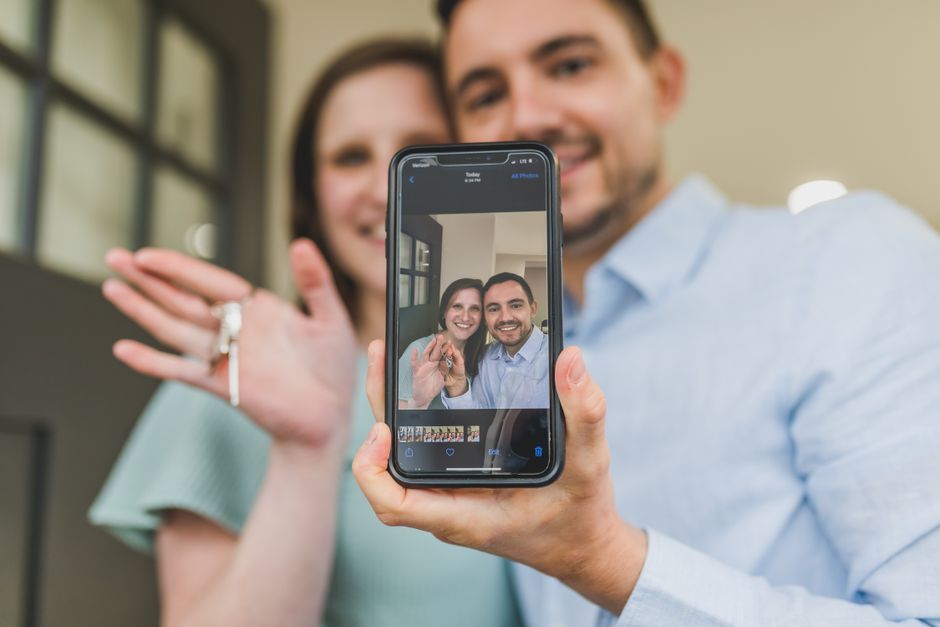 Happy couple taking a selfie while celebrating their new home purchase.
