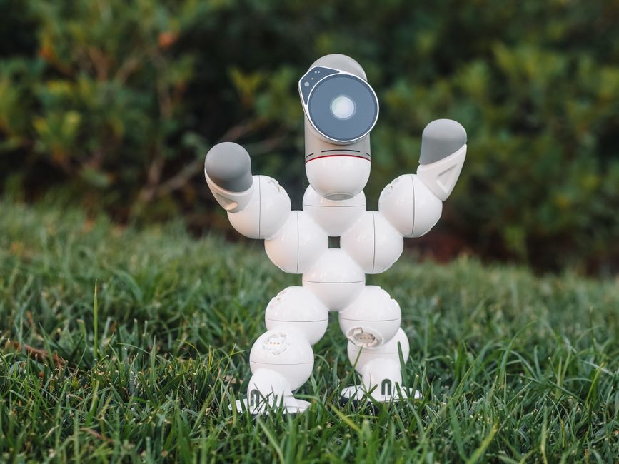 Innovative humanoid robot toy on grass, showcasing modern technology and design.