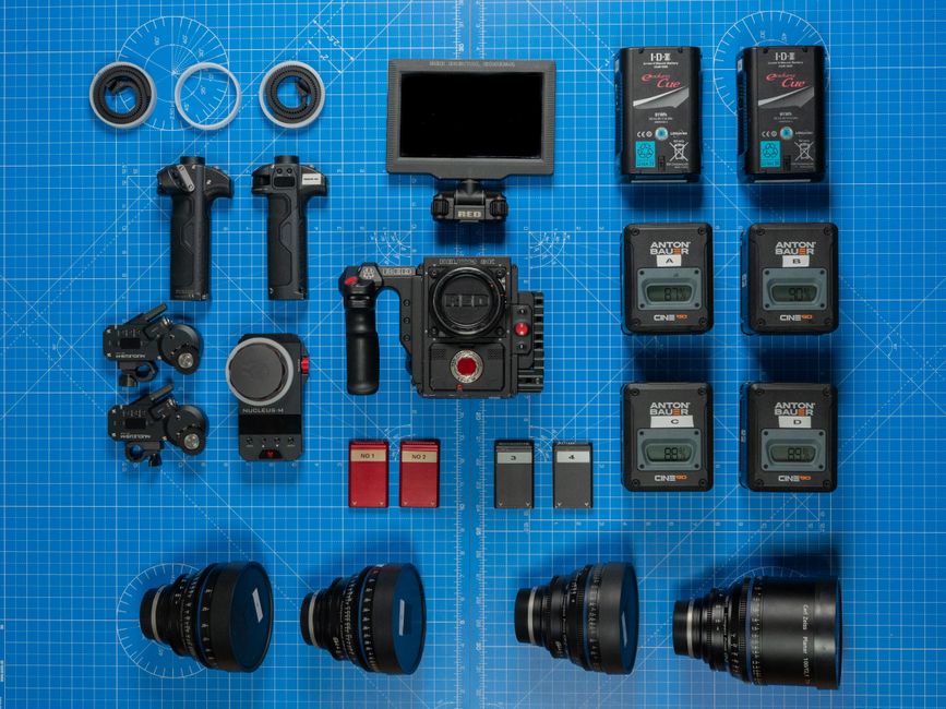 Overhead shot of professional camera gear meticulously arranged on a blueprint surface.