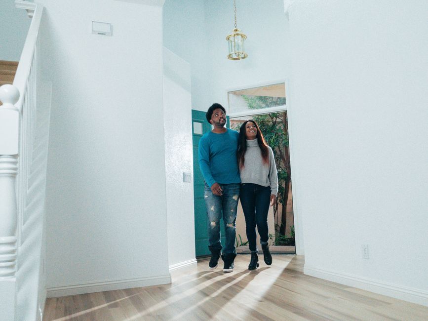 A cheerful couple viewing the interior of their new home, symbolizing new beginnings.