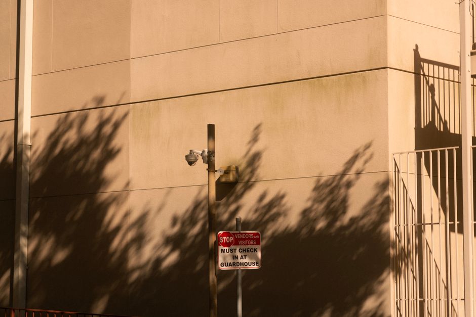 A security camera with shadows on a building wall during sunset in Houston, Texas.