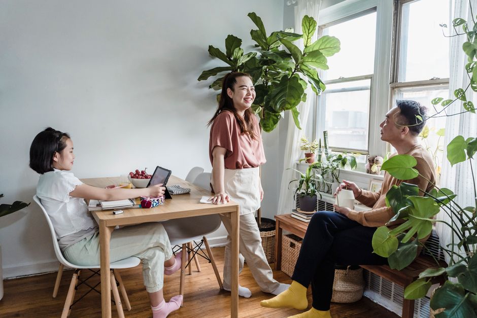 Family spending quality time together in a plant-filled, well-lit living room.