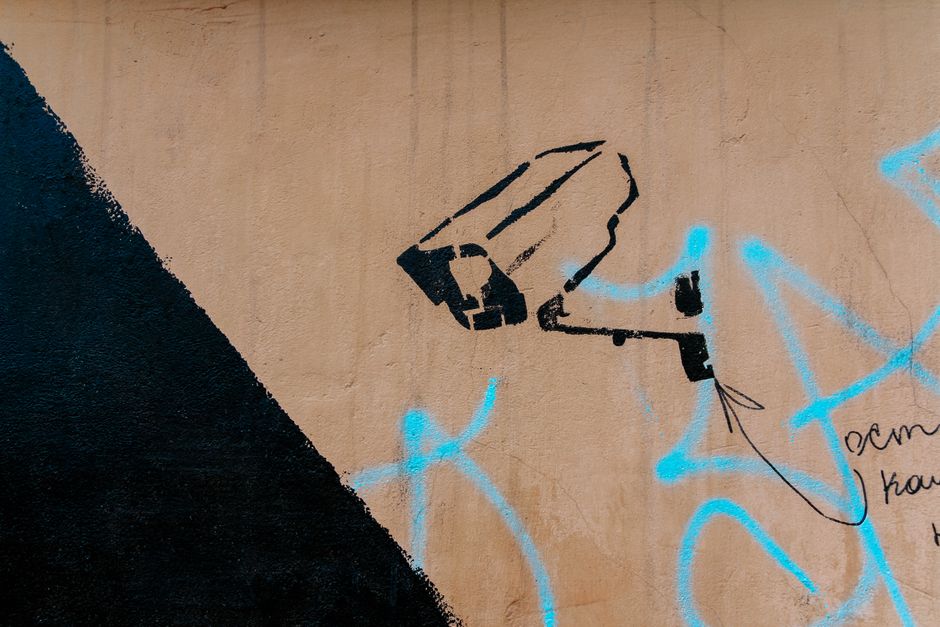 Graffiti art representing a security camera on an urban wall.